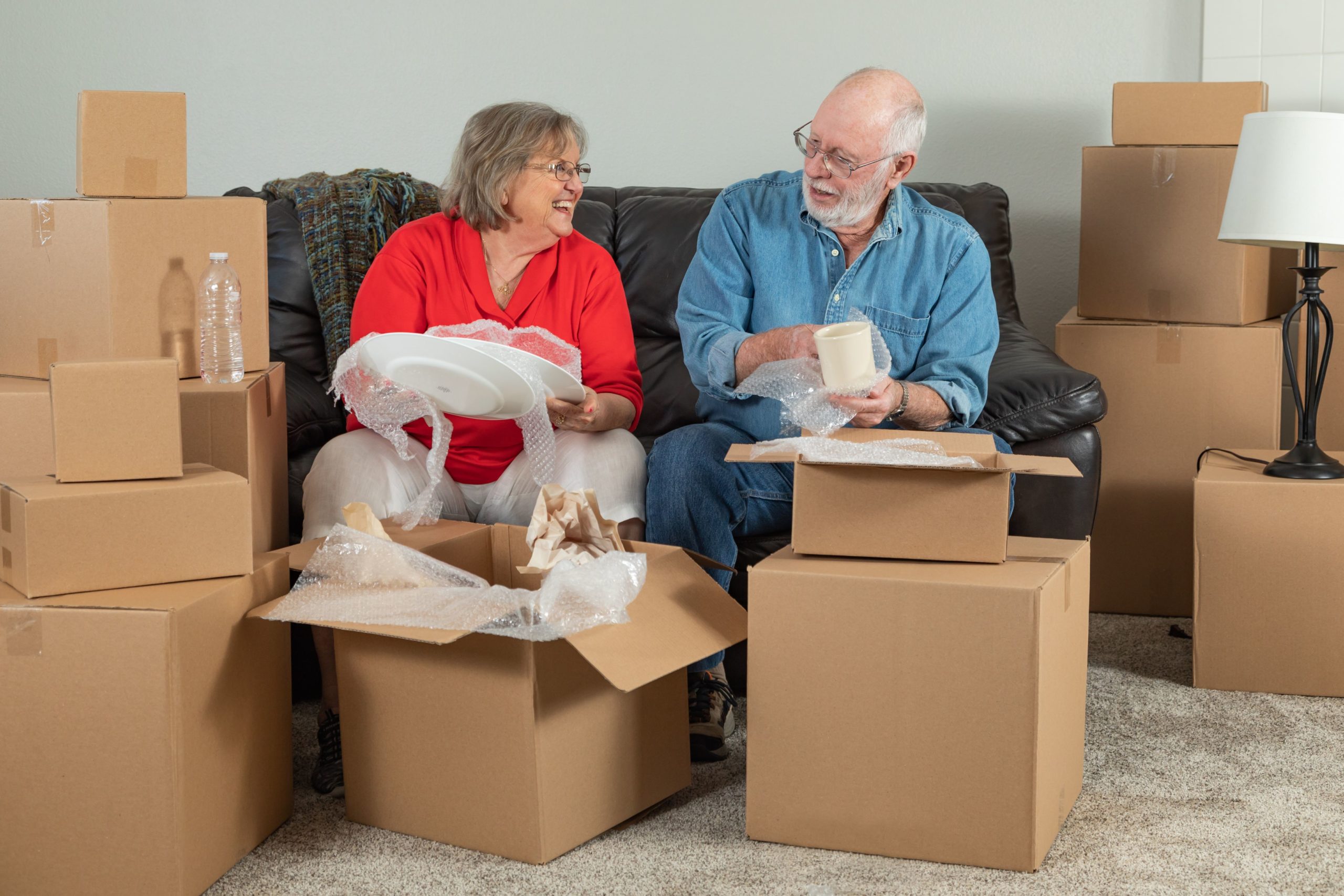 senior adult couple downsizing home by packing boxes