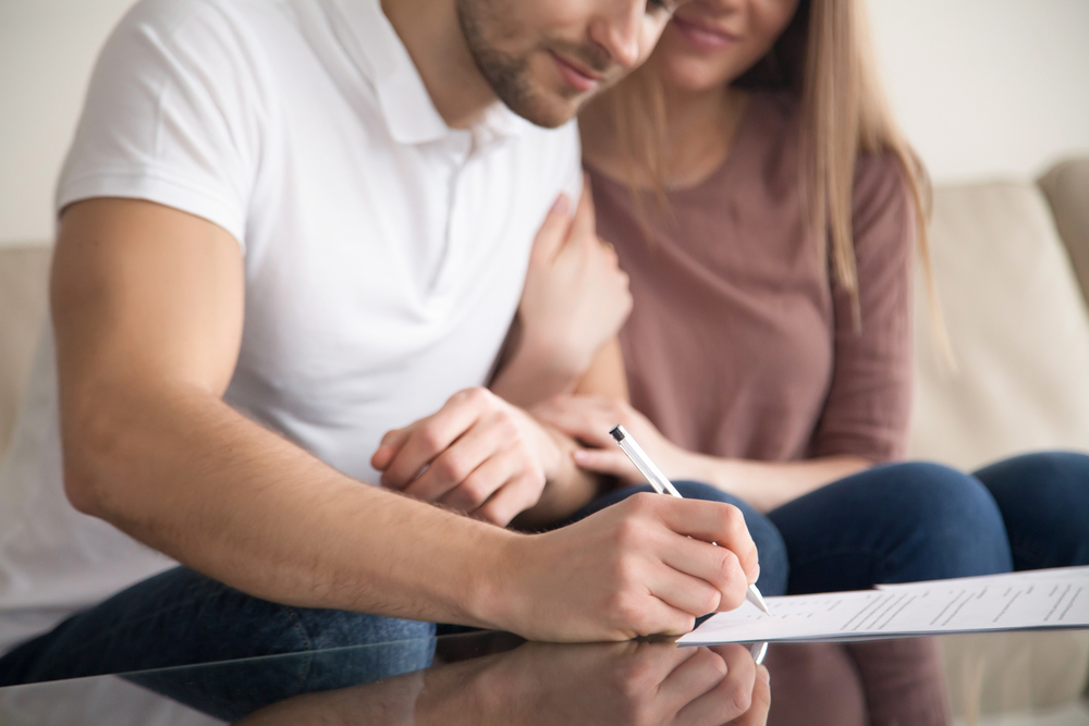 couple signing documents for home sale